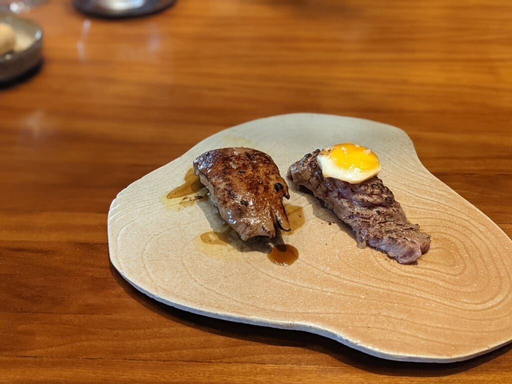 a plate with meat and egg on it