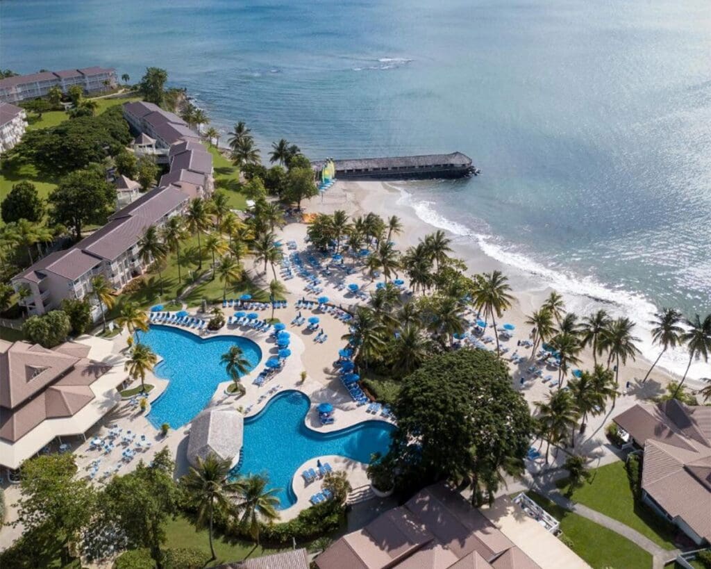 a resort with a beach and a body of water