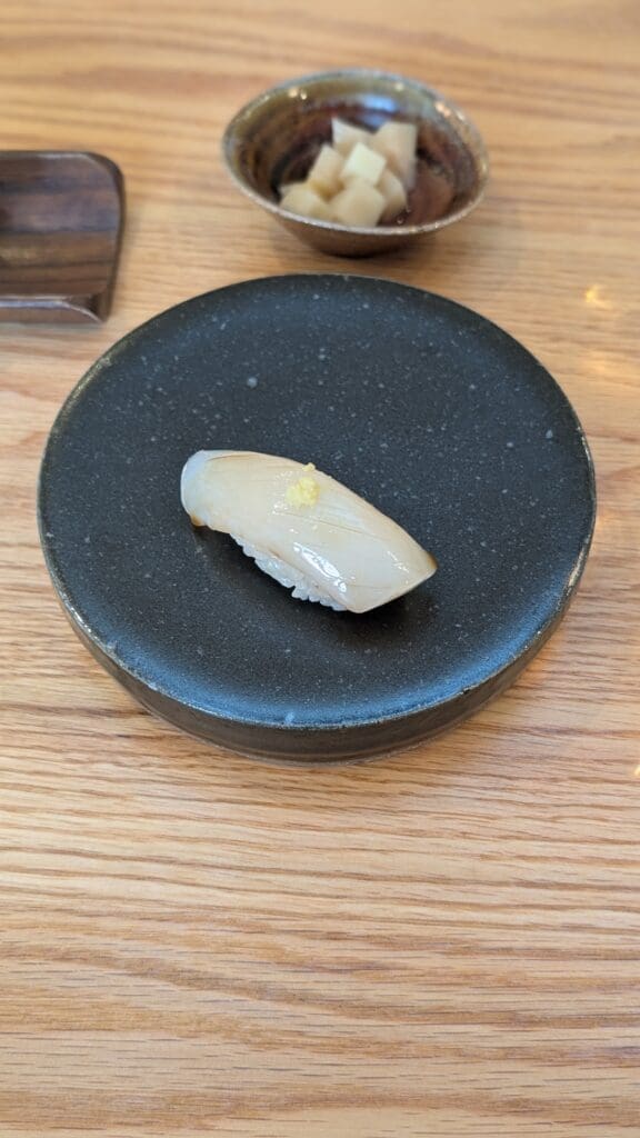a piece of raw fish on a black plate