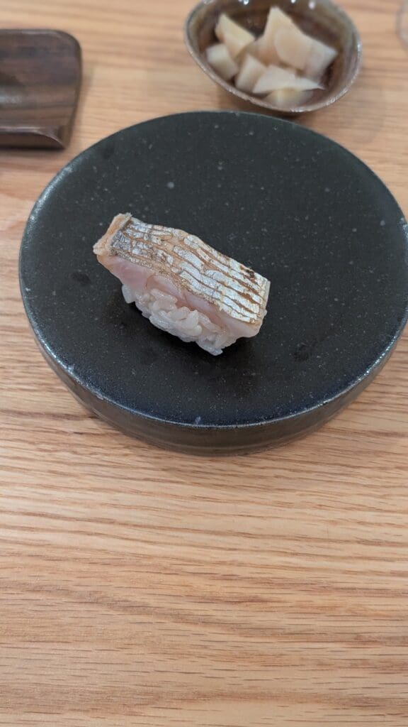 a piece of fish on a black plate