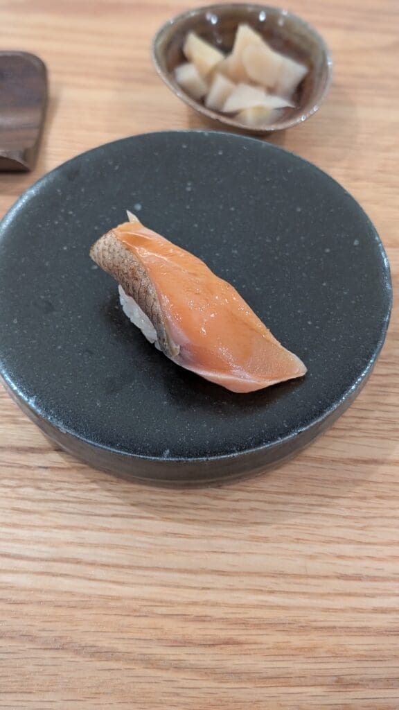a piece of fish on a black plate