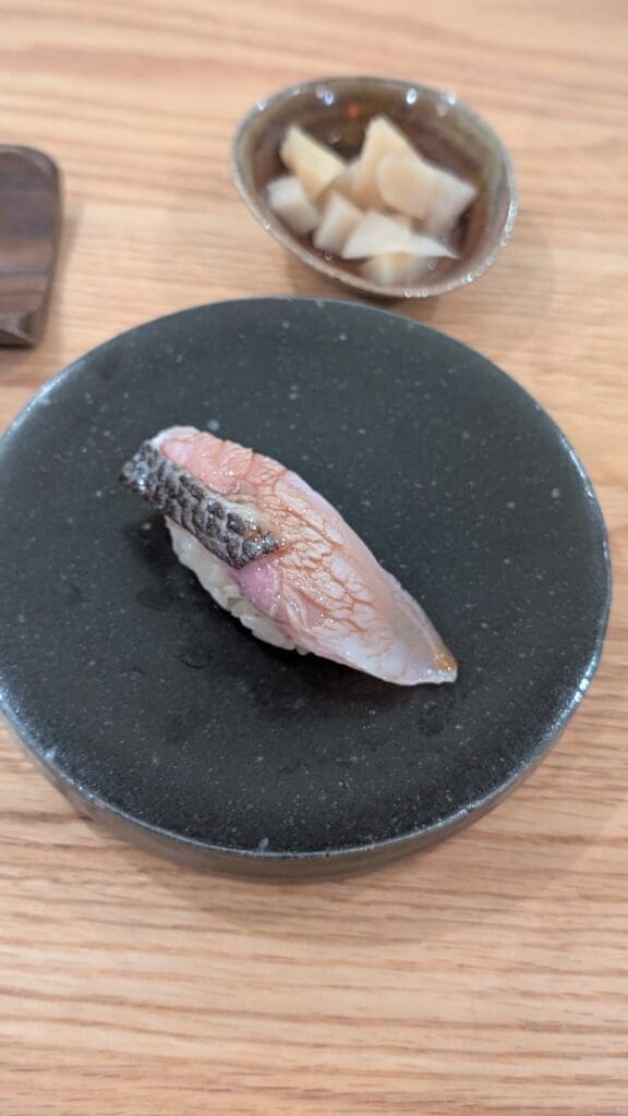 a piece of sushi on a black plate