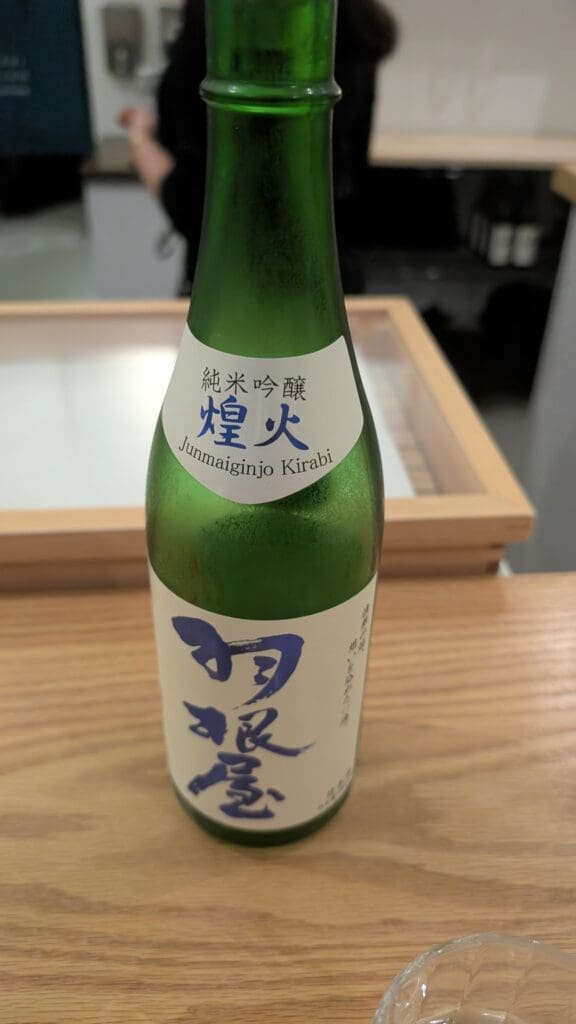 a green bottle with white label on a wood surface