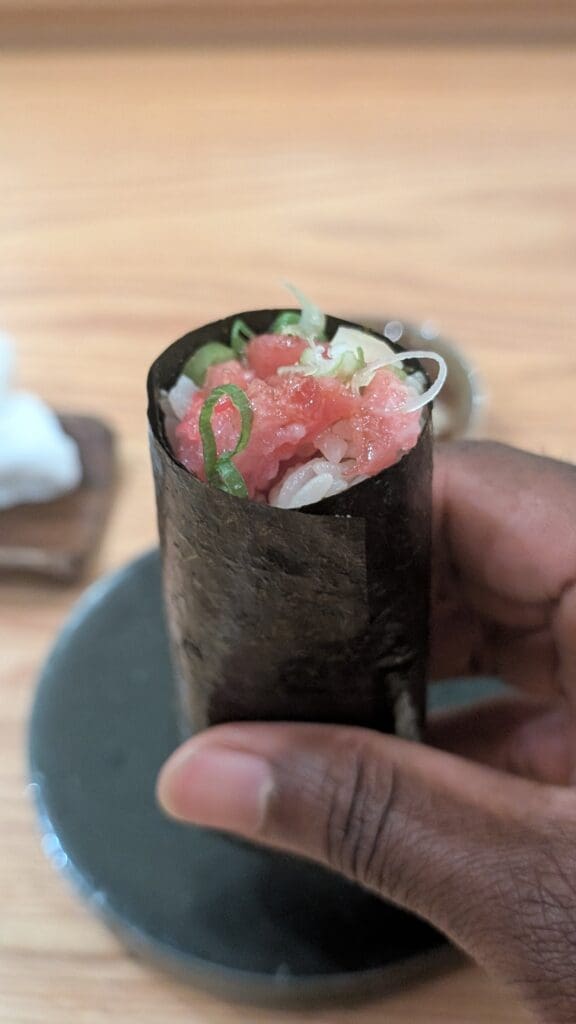 a hand holding a roll of food