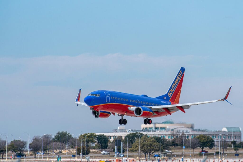 a blue and red airplane taking off