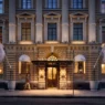 a building with columns and a man walking in front of it