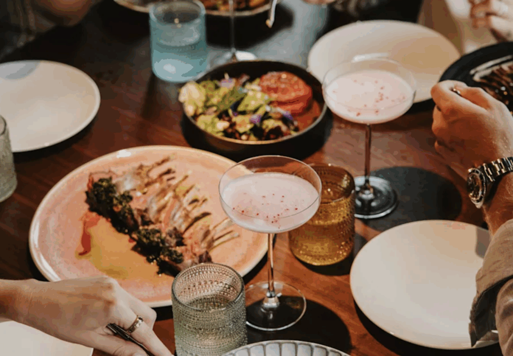 a table with plates of food and glasses of wine