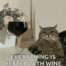 a cat sitting on the floor next to a glass of wine
