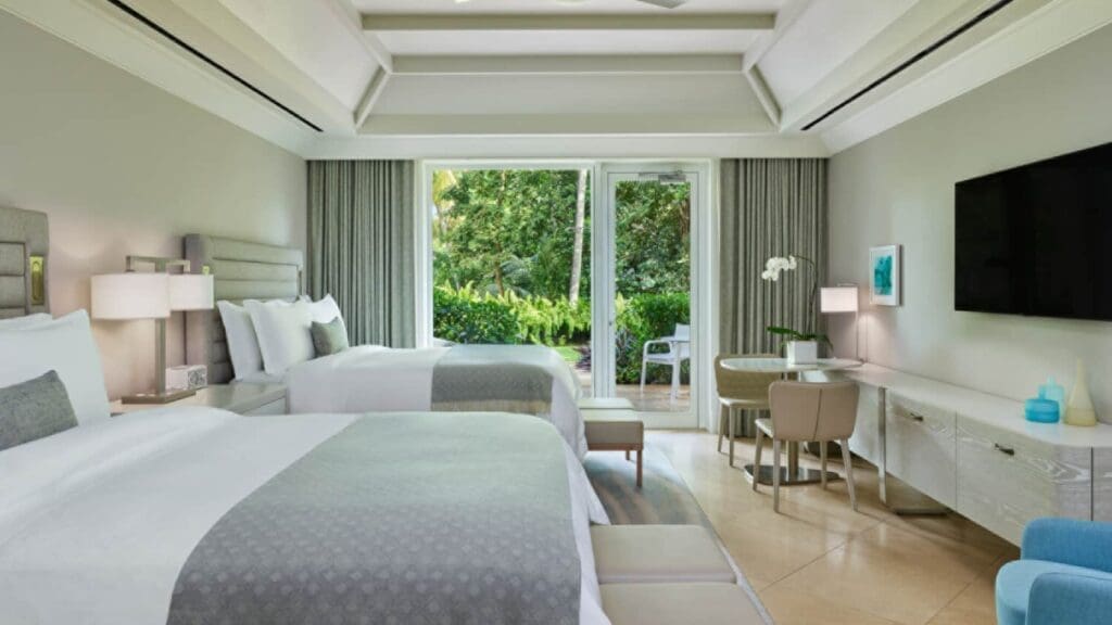 a room with two beds and a table and chairs