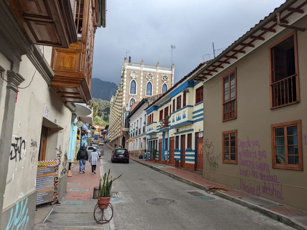 a street with buildings and people walking in Bogotá, Colombia.