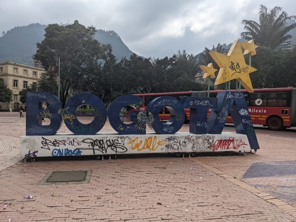 a large blue sign with graffiti on it in Bogotá, Colombia.