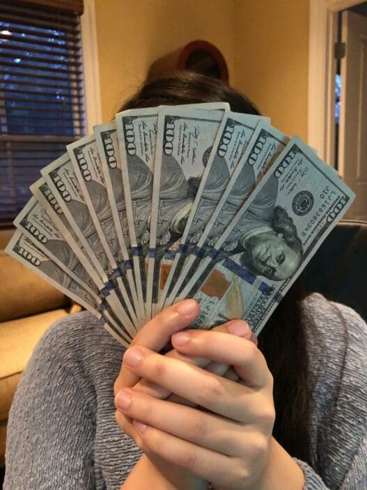 a person holding a fan of money