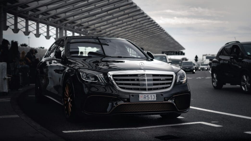 a black car mercedes parked at the airport