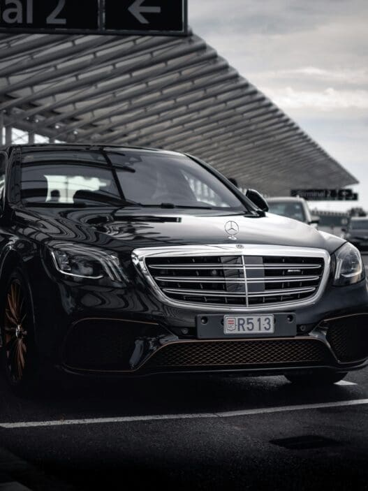a black car mercedes parked at the airport