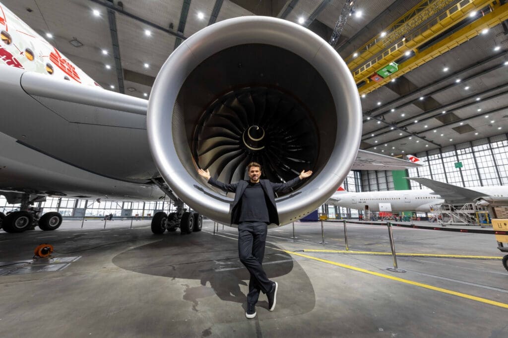 a man standing in front of a large jet engine