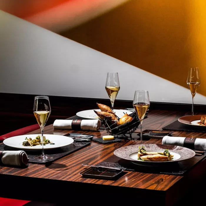 a table with plates of food and wine glasses