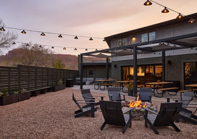 a fire pit with chairs and tables in front of a building