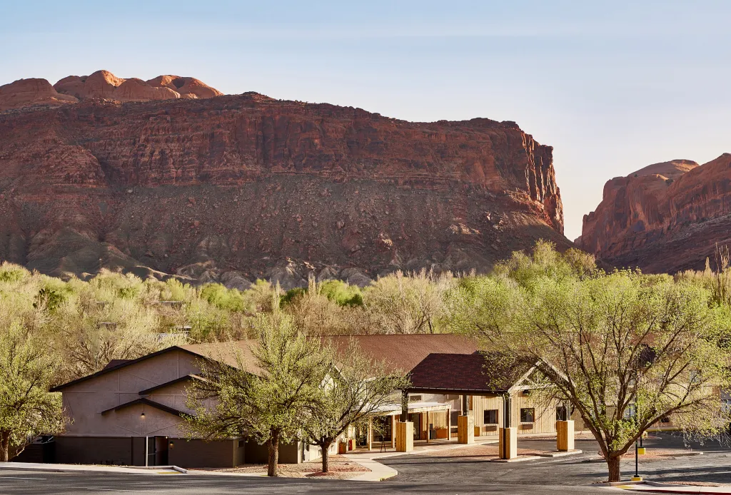 a building with trees and mountains in the background