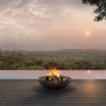 a fire pit on a deck overlooking a river