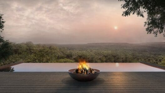 a fire pit on a deck overlooking a river