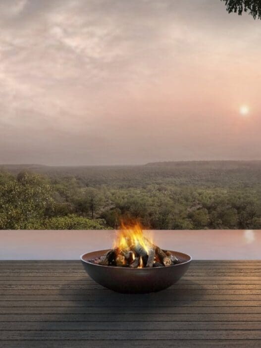 a fire pit on a deck overlooking a river