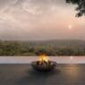 a fire pit on a deck overlooking a river