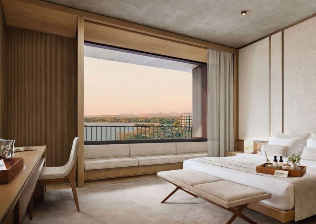 a room with a bed and a window overlooking a river