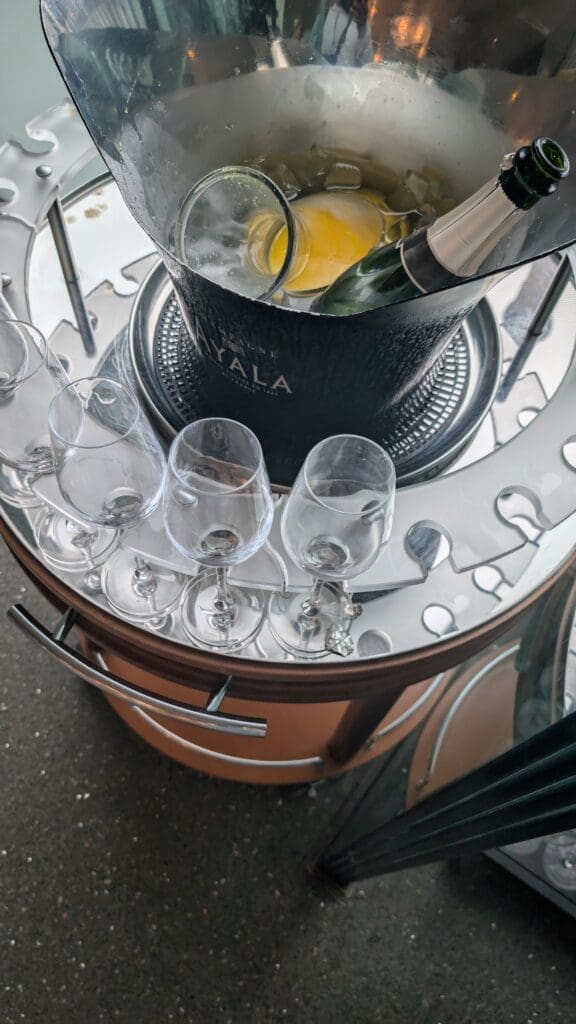 a bucket of champagne and glasses on a table