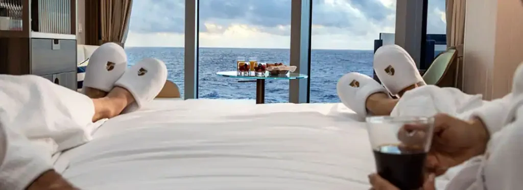 a bed with a glass table and a table with food on it