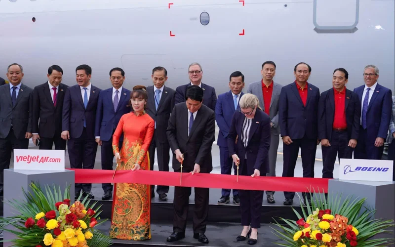 a group of people cutting a red ribbon