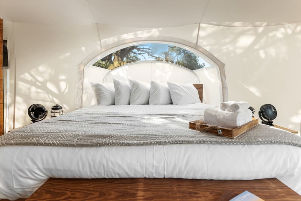 a bed with white sheets and towels on it