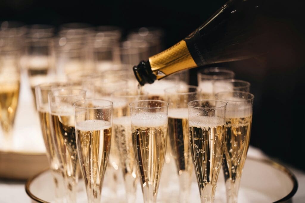 a champagne being poured into a group of glasses