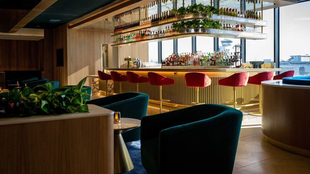 a bar with chairs and a shelf with bottles