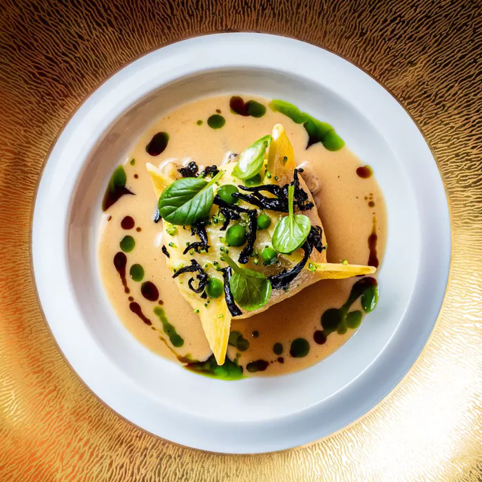 a plate of food with sauce and herbs