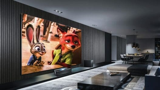 a room with a large screen and a coffee table