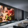 a room with a large screen and a coffee table