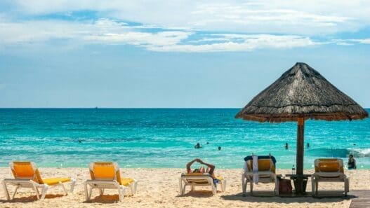 a beach with chairs and umbrellas