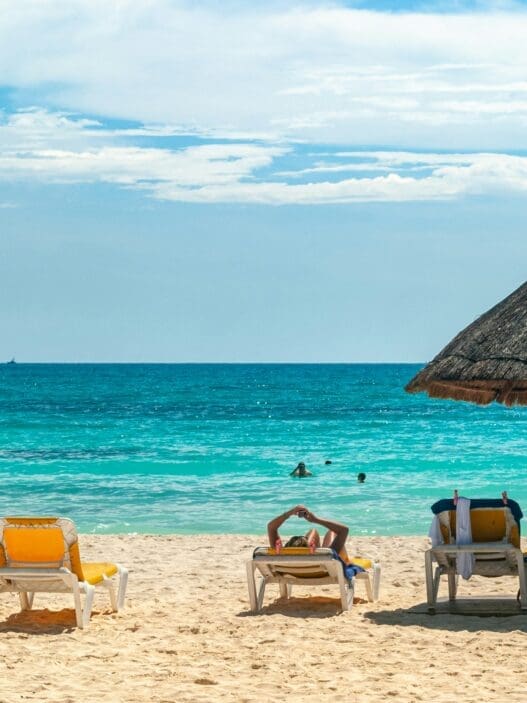 a beach with chairs and umbrellas