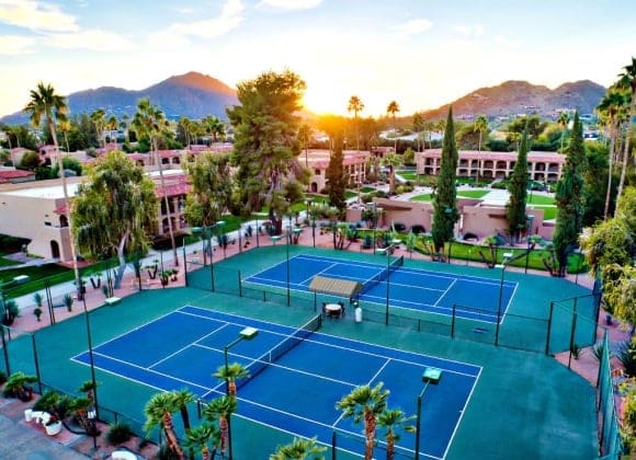 a tennis court surrounded by trees