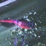 a downed (crash) red helicopter on the side of the road