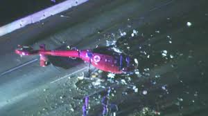 a downed (crash) red helicopter on the side of the road