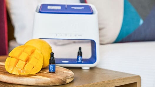 a small bottle of essential oil next to a fruit