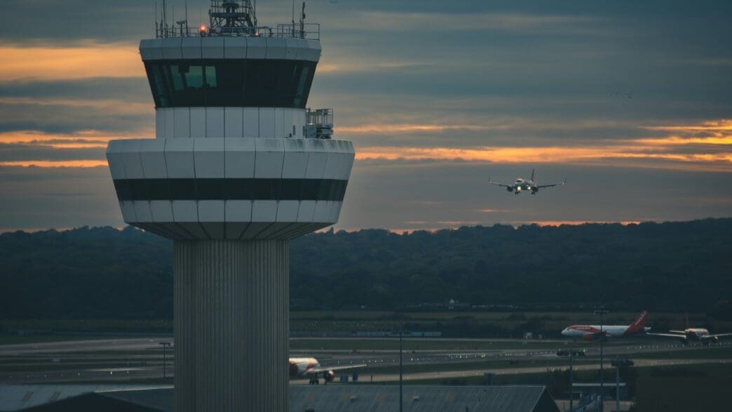 a plane flying over a control tower