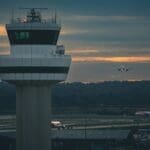 a plane flying over a control tower