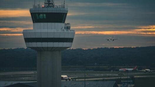 a plane flying over a control tower
