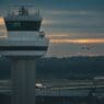 a plane flying over a control tower