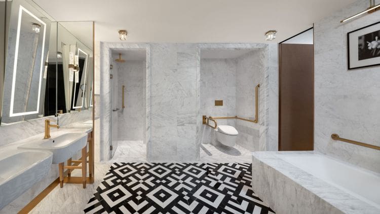 a bathroom with marble walls and a black and white patterned floor