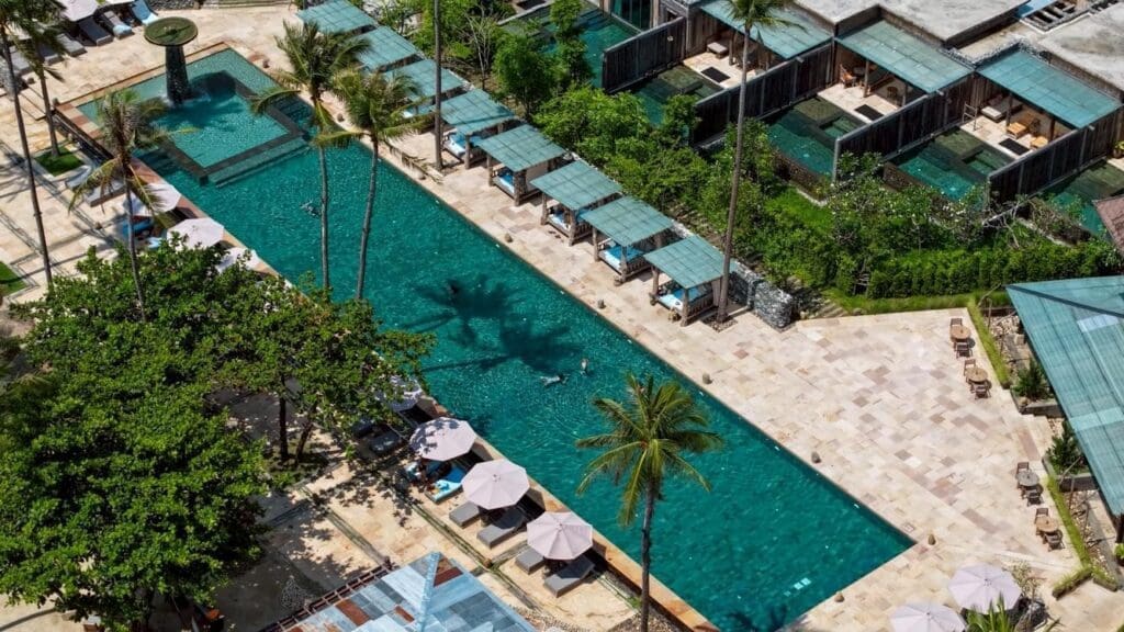 a swimming pool with umbrellas and trees