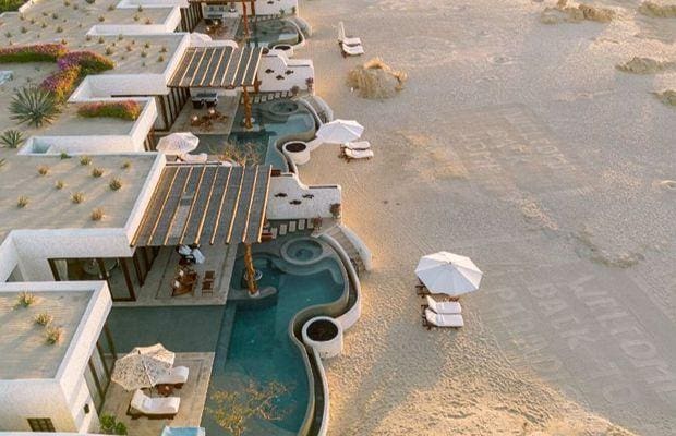 a swimming pool and lounge chairs on a beach