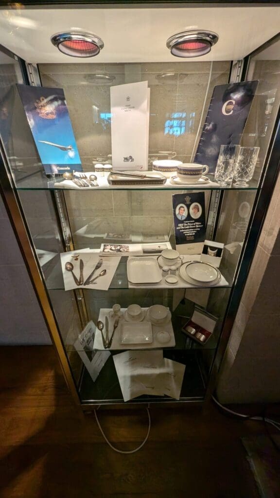a glass cabinet with silverware and plates